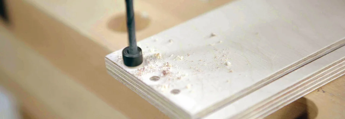 Bohrer bohrt Loch in Holzbrett